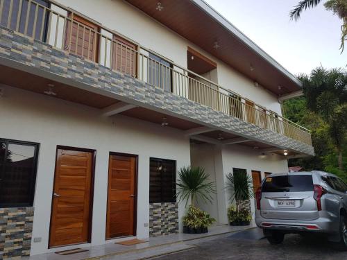 un coche aparcado delante de una casa en FLB Apartelle Los Banos, en Los Baños