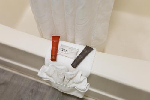 a white towel with a razor and a bottle on it at Admiral Motel in Lake George