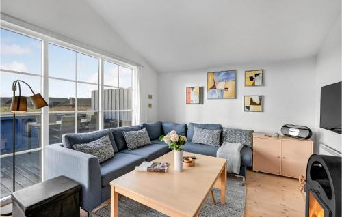 a living room with a blue couch and a table at Amazing Home In Hvide Sande With Wifi in Hvide Sande