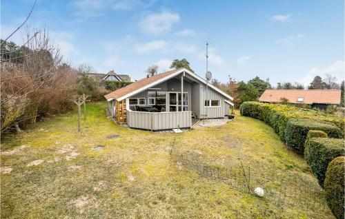a small white house in a yard with bushes at Gorgeous Home In Ebeltoft With Sauna in Ebeltoft