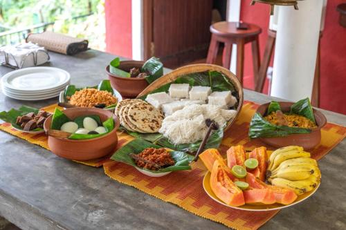 a table topped with plates of food on a table at Kuru Ganga Villa in Eratnagoda