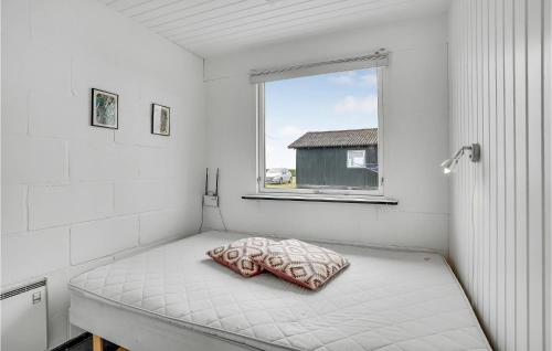 a white room with a bed with a pillow on it at Nice Home In Haderslev With Kitchen in Kelstrup Strand