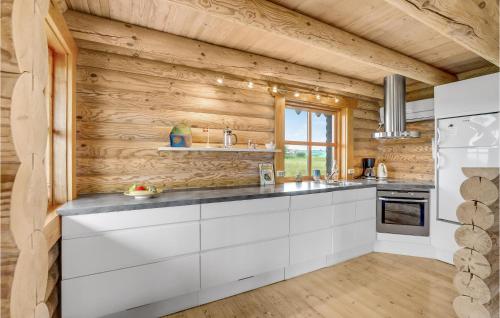 FurにあるAmazing Home In Fur With Kitchenの白いキャビネットと木製の壁が備わるキッチン