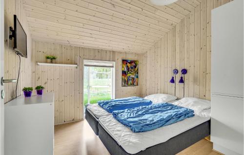 1 dormitorio con cama con sábanas azules y ventana en Gorgeous Home In Give With Wifi, en Lindet