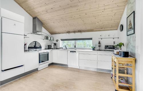 a kitchen with white cabinets and a wooden ceiling at Holiday Home Give 37 in Give
