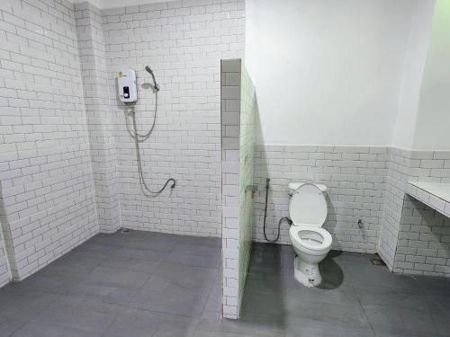 a bathroom with a toilet and a shower at Baan U Sabai Poshtel (บ้านอยู่สบาย พอสเทล) 