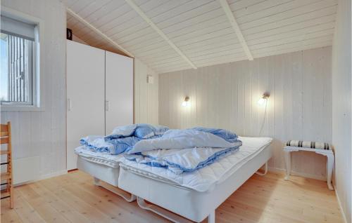 ÅrøsundにあるAmazing Home In Haderslev With 4 Bedrooms, Sauna And Wifiの白いベッド(青いシーツ付)