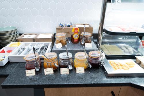 a kitchen counter with jars of honey and food at Holiday Inn Calais-Centre by IHG in Calais
