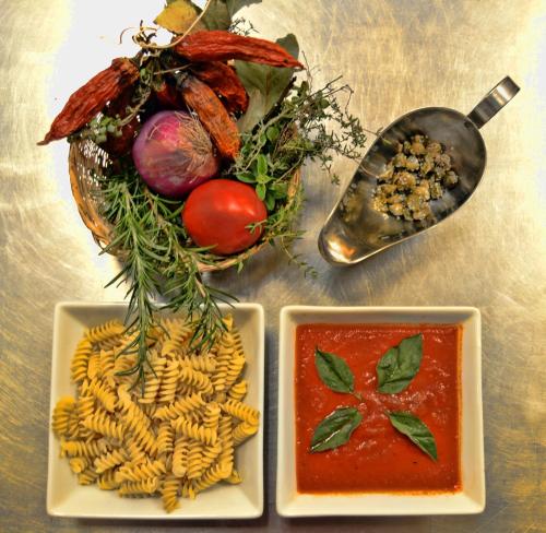 a table with three plates of pasta and a bowl of sauce at Posada Las Bromelias in Silvania