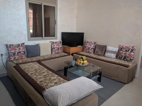 Sala de estar con 2 sofás y TV en amal's apart&studio en Agadir