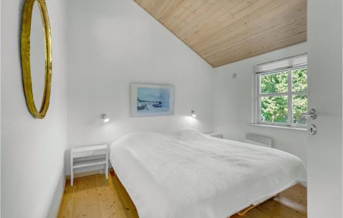 Fjand GårdeにあるLovely Home In Ulfborg With Kitchenの白いベッドルーム(大型ベッド1台、鏡付)