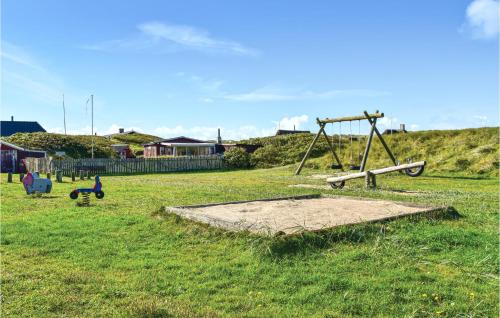 an empty playground in a field with a swing at Two-Bedroom Holiday Home In Ulfborg in Fjand Gårde