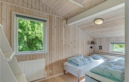 Habitación con paredes de madera, cama y ventana. en 3 Bedroom Cozy Home In Hjslev, en Bøstrup