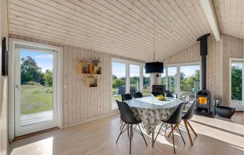 a dining room with a table and chairs and a fireplace at Holiday Home Højslev 42 in Bøstrup