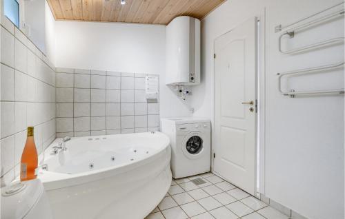 a white bathroom with a tub and a washing machine at Amazing Home In Ebeltoft With 2 Bedrooms And Wifi in Ebeltoft