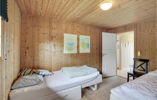 Hvalpsundにある3 Bedroom Awesome Home In Farsの木製の壁のベッドルーム1室、ベッド1台、ソファが備わります。