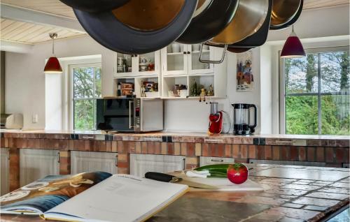 a kitchen with a table with an apple on it at 3 Bedroom Awesome Home In Bækmarksbro in Bækmarksbro