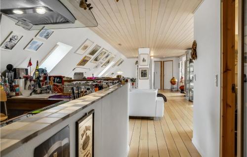 a kitchen and living room with white walls and wood floors at 3 Bedroom Awesome Home In Bækmarksbro in Bækmarksbro