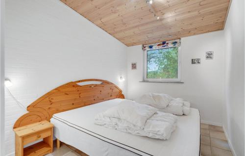 a bedroom with a bed with white sheets and a window at Amazing Home In Ebeltoft With 2 Bedrooms And Wifi in Ebeltoft