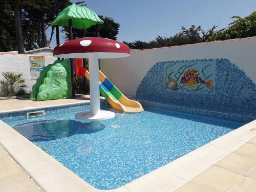 a pool with a slide and an umbrella at Camping Le Transat in Foulerot