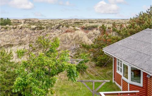 a small red house in the middle of a field at Holiday Home Svenstibakkevej Denmark Ii in Lild Strand