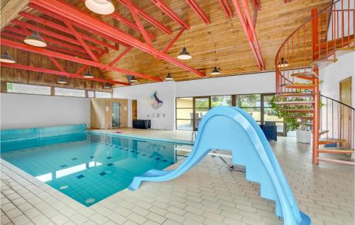a swimming pool with a slide in a building at Rishøj in Hjarbæk