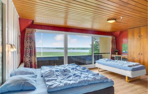 um quarto com 2 camas e uma grande janela em Rishj em Hjarbæk