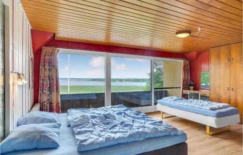 a bedroom with two beds and a large window at Rishøj in Hjarbæk