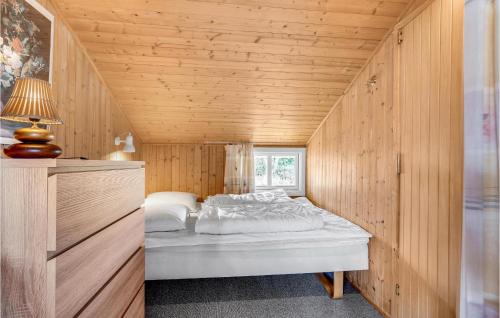 Lild StrandにあるBeautiful Home In Frstrup With 2 Bedrooms, Sauna And Wifiの木製の部屋にベッド1台が備わるベッドルーム1室があります。