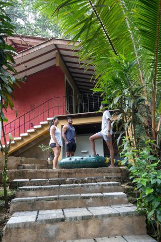 a group of people standing on steps in front of a house at Kuru Ganga Villa in Eratnagoda