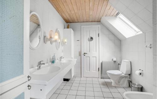 La salle de bains blanche est pourvue d'un lavabo et de toilettes. dans l'établissement Rishj, à Hjarbæk