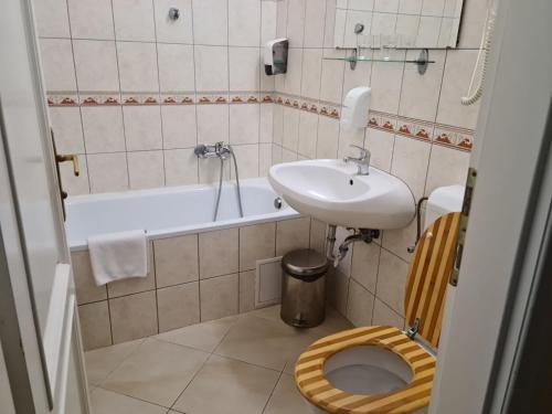 een badkamer met een wastafel, een toilet en een bad bij Teleki-Wattay Kastélyszálló in Pomáz