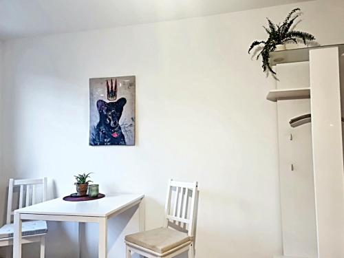 a white dining room with a white table and chair at Banaba in Wiesbaden