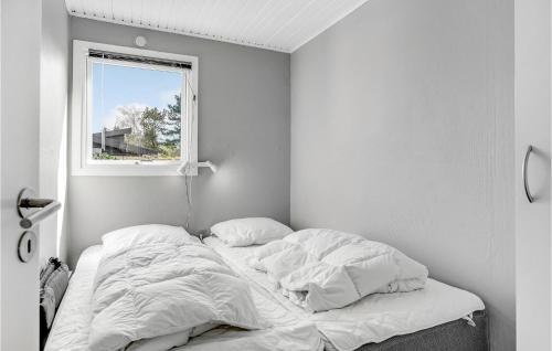 ein unmaskiertes Bett in einem weißen Zimmer mit einem Fenster in der Unterkunft 3 Bedroom Lovely Home In Sydals in Skovby