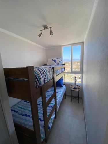 a small bedroom with a bunk bed and a window at Marina Costa in Coquimbo