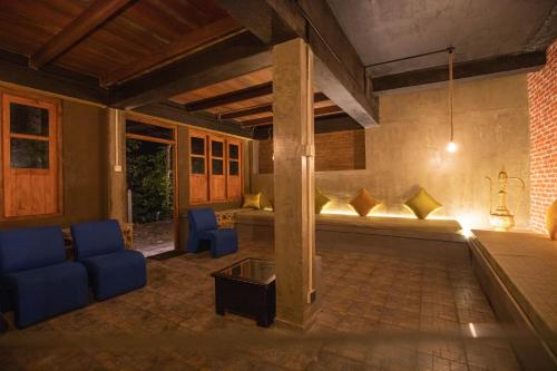 a living room with blue chairs and a table at Kuru Ganga Villa in Eratnagoda