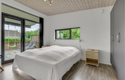 SkovbyにあるAmazing Home In Sydals With 3 Bedrooms, Sauna And Wifiの白いベッドルーム(ベッド1台、バルコニー付)