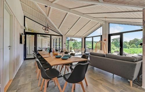a dining room with a table and chairs and a couch at Cozy Home In Ejstrupholm in Ejstrup