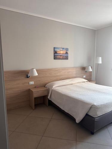 1 dormitorio con 1 cama grande y 2 lámparas en Arenaria room & breakfast Ganzirri en Messina