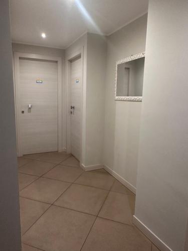 a hallway with a white door and a tile floor at Arenaria room & breakfast Ganzirri in Messina