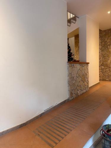 un pasillo con una pared blanca y una pared de piedra en Arenaria room & breakfast Ganzirri en Messina