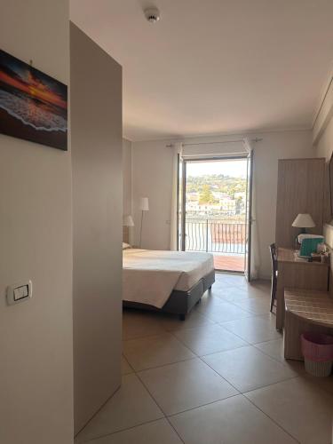 1 dormitorio con cama y vistas a un balcón en Arenaria room & breakfast Ganzirri en Messina