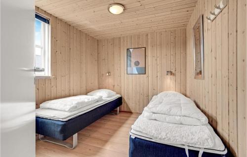 two beds in a room with wooden walls at Nice Home In Sydals With 7 Bedrooms, Sauna And Wifi in Høruphav