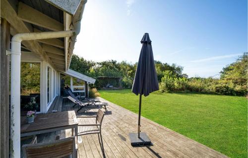 an umbrella sitting on the deck of a house at Nice Home In Sydals With Wifi in Høruphav