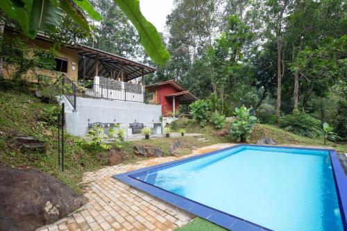 a swimming pool in front of a house at Kuru Ganga Villa in Eratnagoda