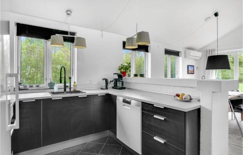 a kitchen with black and white counters and windows at Holiday Home Stærevænget Kirke Hyllinge Iii in Kirke-Hyllinge