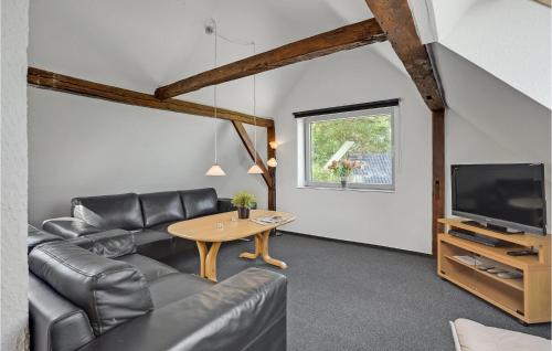 a living room with a couch and a table and a tv at Holiday Home Grønmark in Høruphav