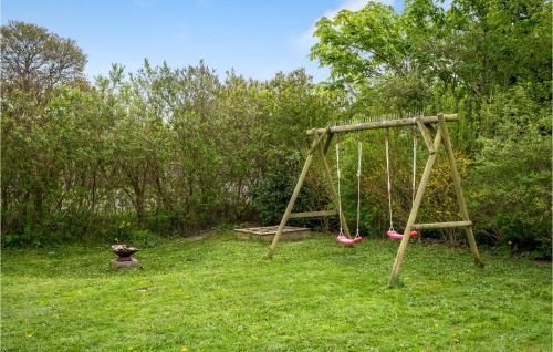 a swing set in a yard with grass and trees at Holiday Home Stærevænget Kirke Hyllinge Iii in Kirke-Hyllinge