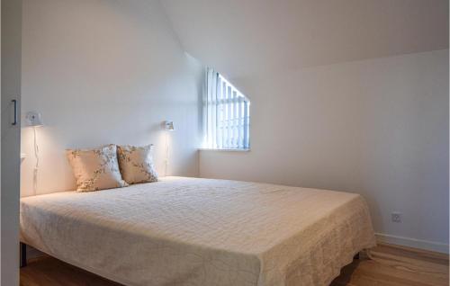 a bedroom with a large bed with a window at Beautiful Home In Otterup With Kitchen in Tørresø