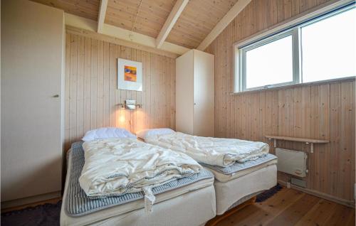 two twin beds in a room with a window at Awesome Home In Ebeltoft With 3 Bedrooms, Sauna And Wifi in Ebeltoft